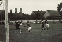 Fussballspiel auf dem &bdquo;alten&ldquo; Sportplatz im Dorf mit Kircht&uuml;rmen im Hintergrund